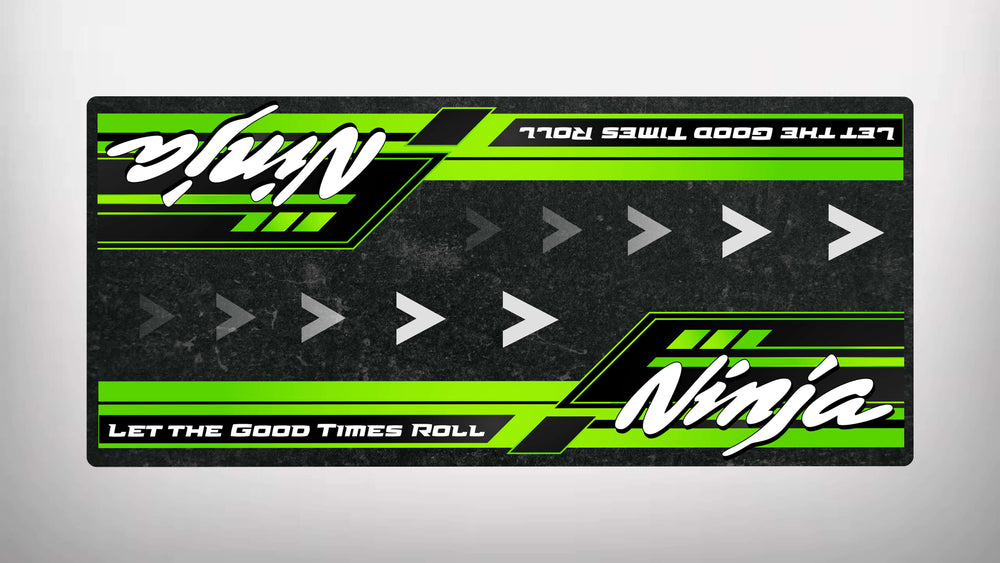 The Motorcycle Pit Mat for Kawasaki Ninja features a green and black striped rectangular decal with right-pointing arrows. Ninja appears in white, along with the slogan Let the Good Times Roll at the bottom in white text on a green background—ideal for any motorcycle enthusiast.