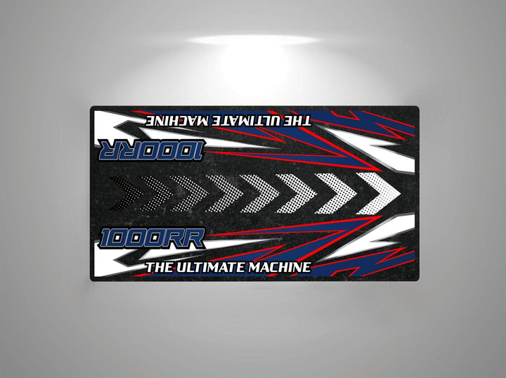 A rectangular black Motorcycle Pit Mat for Honda CBR1000RR with blue and red accents, features bold white arrows pointing right, plus the text 1000RR and THE ULTIMATE MACHINE in blue and white.